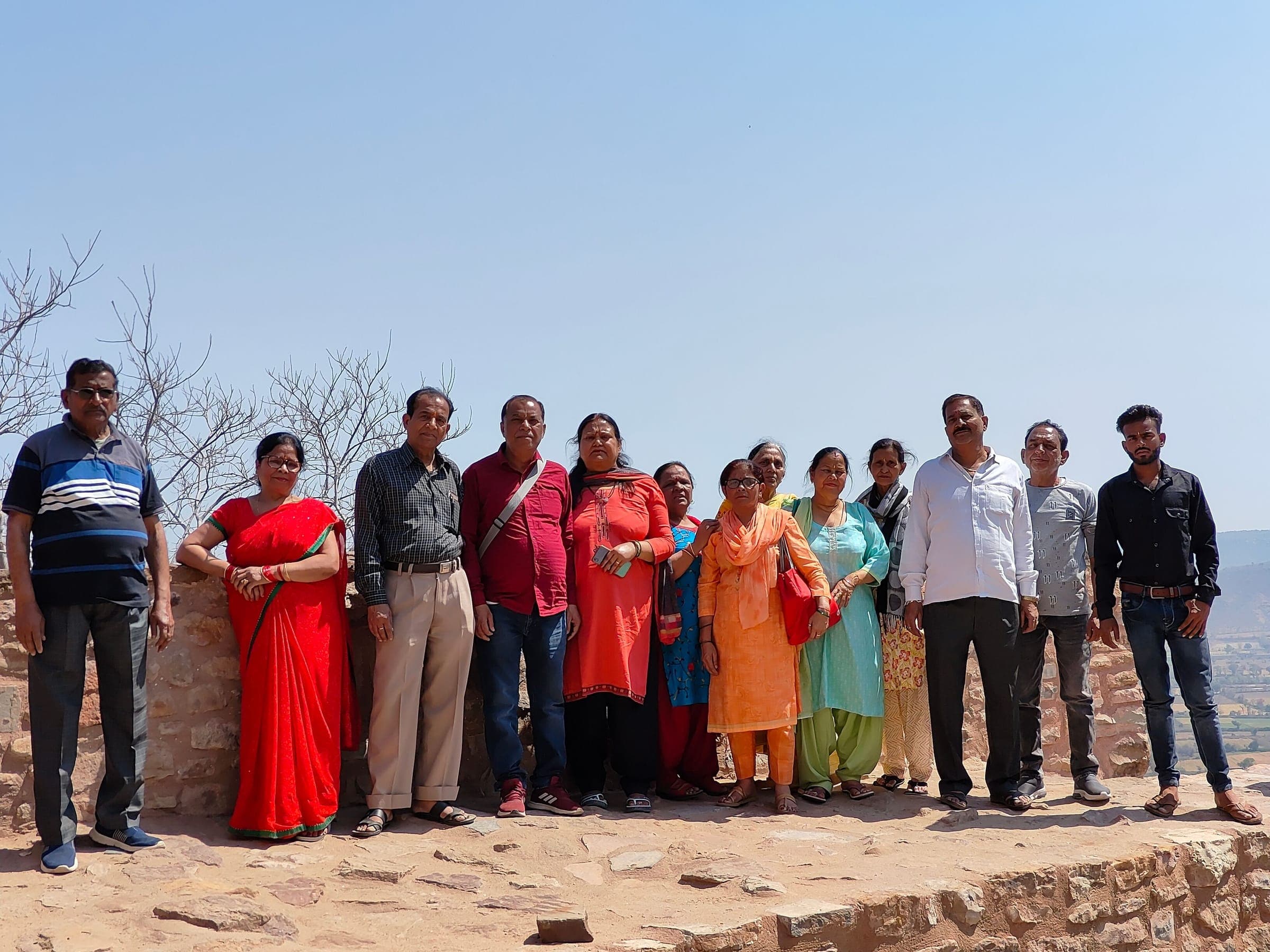 A group of travellers on the stone ramparts of Chittorgarh Fort, with the plains far below