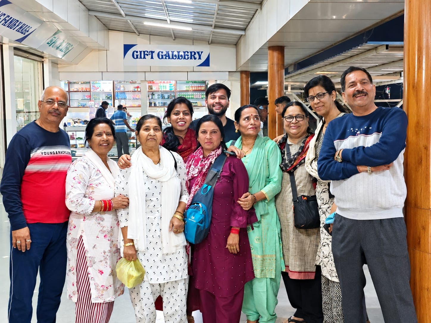 A group of travellers smiling together outside a gift shop during a stop on their tour