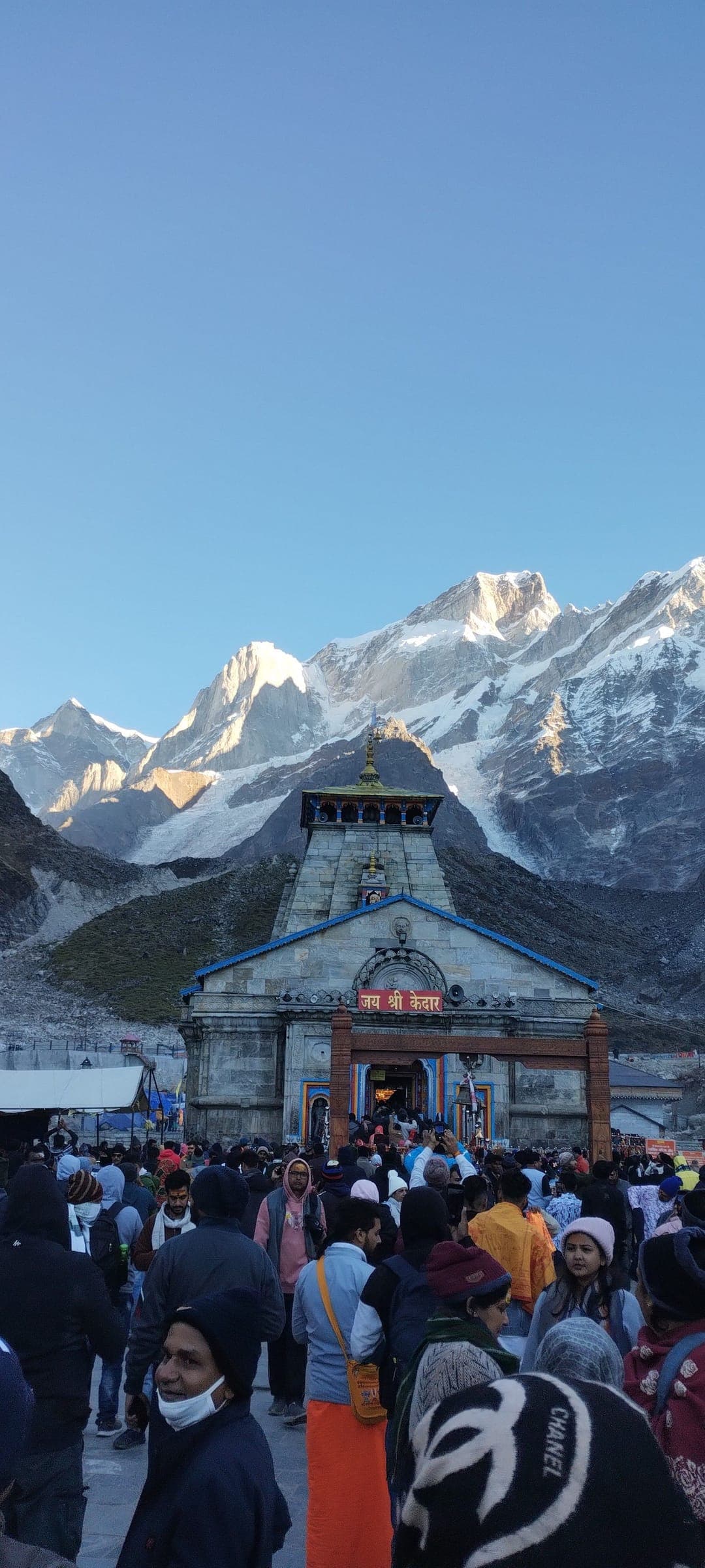 Pilgrims crowding the approach to Kedarnath Temple beneath snow-covered peaks